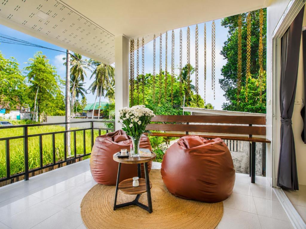 a balcony with two bean bags and a table at Boho House - 2mn Srithanu - King Bed - 4K SmartTV in Hinkong