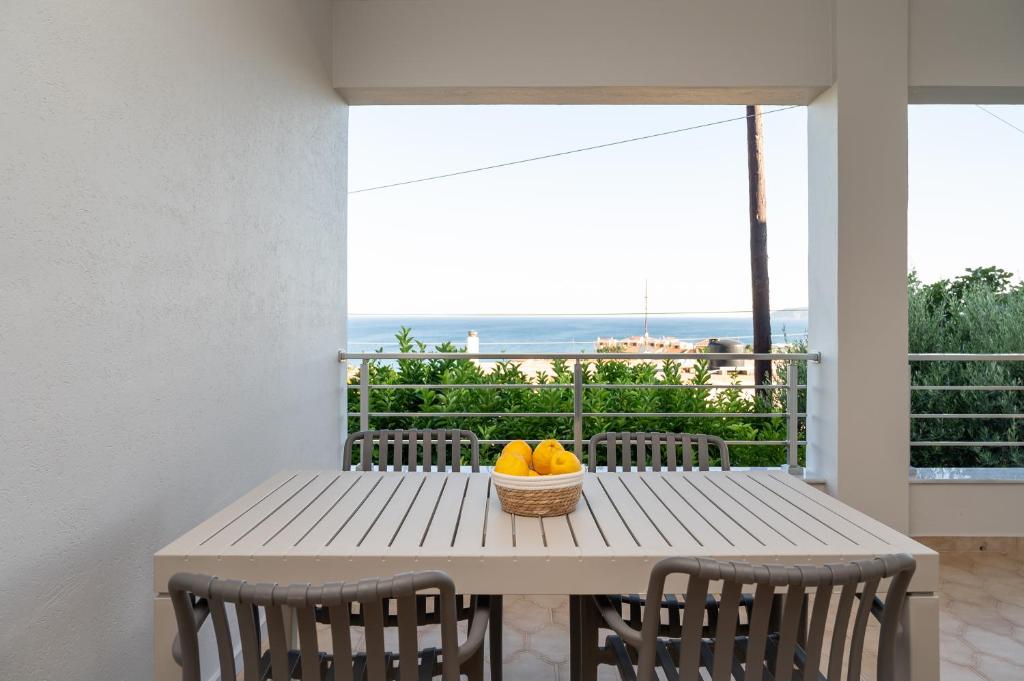 a table with a bowl of oranges on a balcony at Anemi Residence in Chios