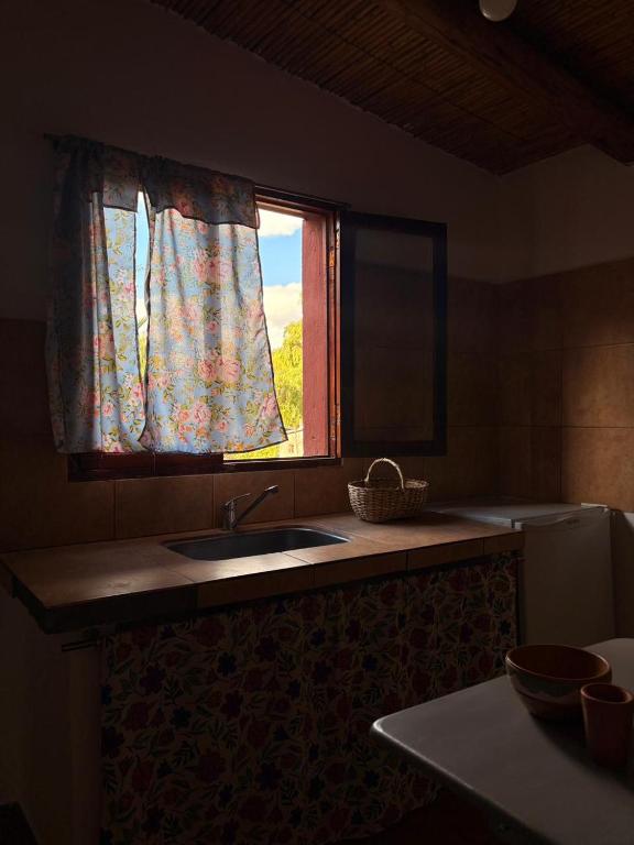 a kitchen with a sink and a window at Cabañas tilcara sarahuayco in Tilcara