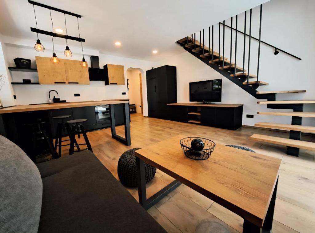 a living room with a table and a staircase at Riverside Apartma 1, Kranjska Gora in Kranjska Gora