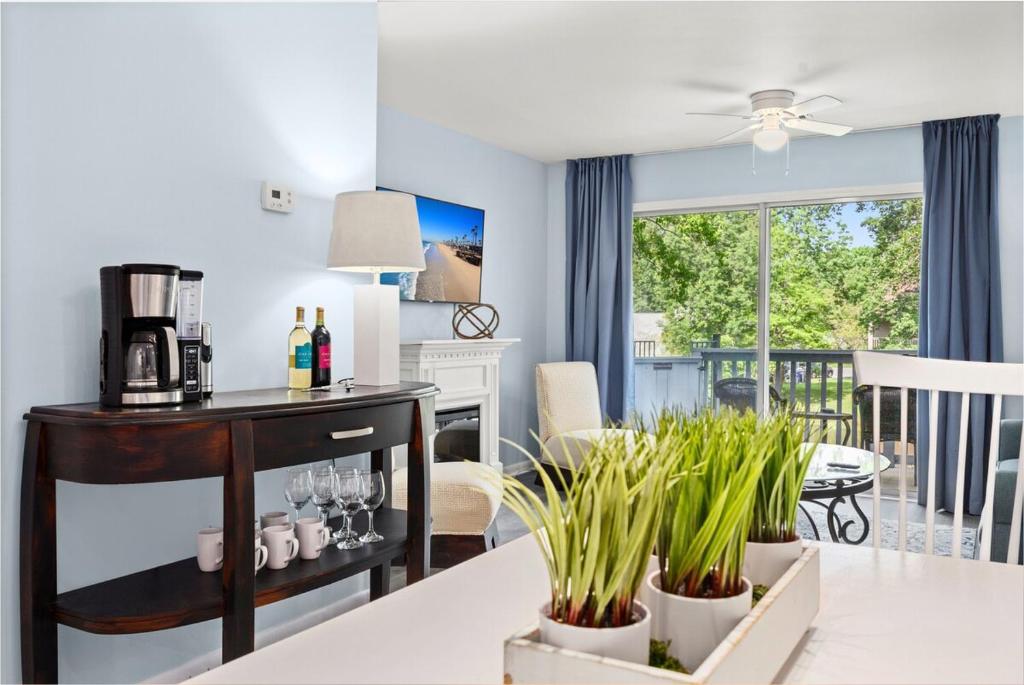 a kitchen and dining room with a table with plants at Tranquil Condo with Pond View in Charleston