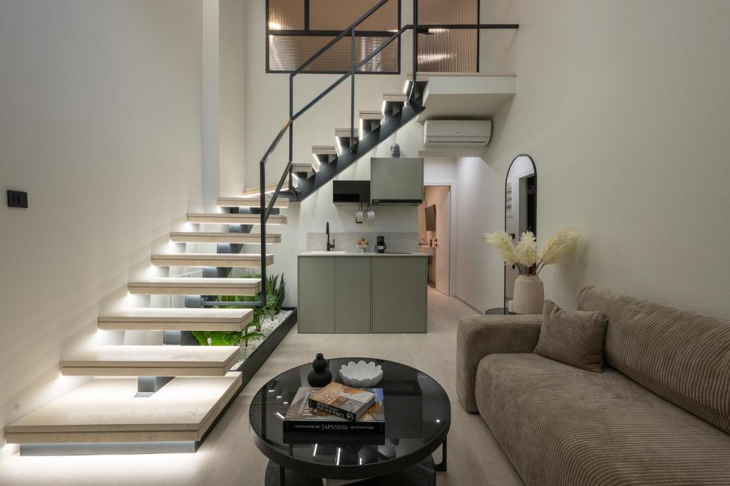 a living room with a staircase and a couch at NOMA Suites in Kalamata