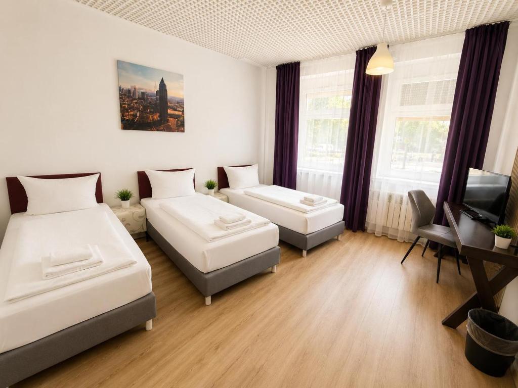 a hotel room with two beds and a television at Pension Reiter in Berlin