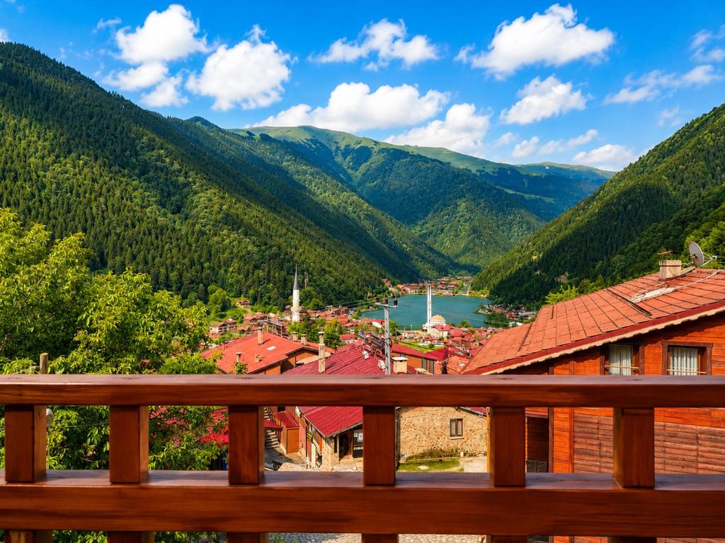 a view of a town from a wooden bench at Şimo Suite Otel in Uzungöl