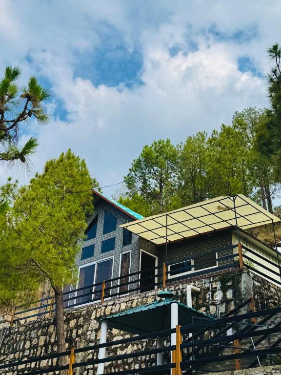 a blue house with a metal roof on a porch at The Margallia in Islamabad