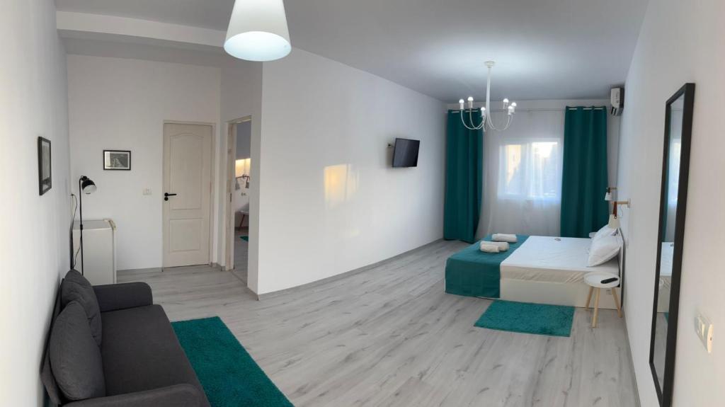 a bedroom with a bed and a living room with a couch at Casa Happy in 2 Mai