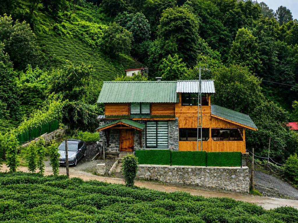 a wooden house with a car parked in front of it at Altın Vadi Konaklama in Fındıklı