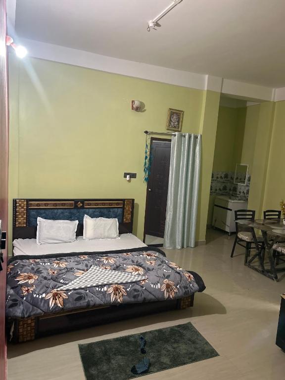 a bedroom with a bed and a table and chairs at JAJABAR Homestay in Dum Duma