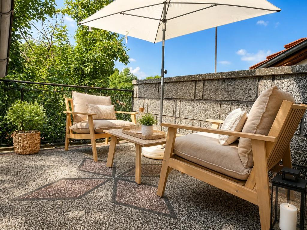 a patio with two chairs and a table and an umbrella at Mountain View Apartment in Troyan