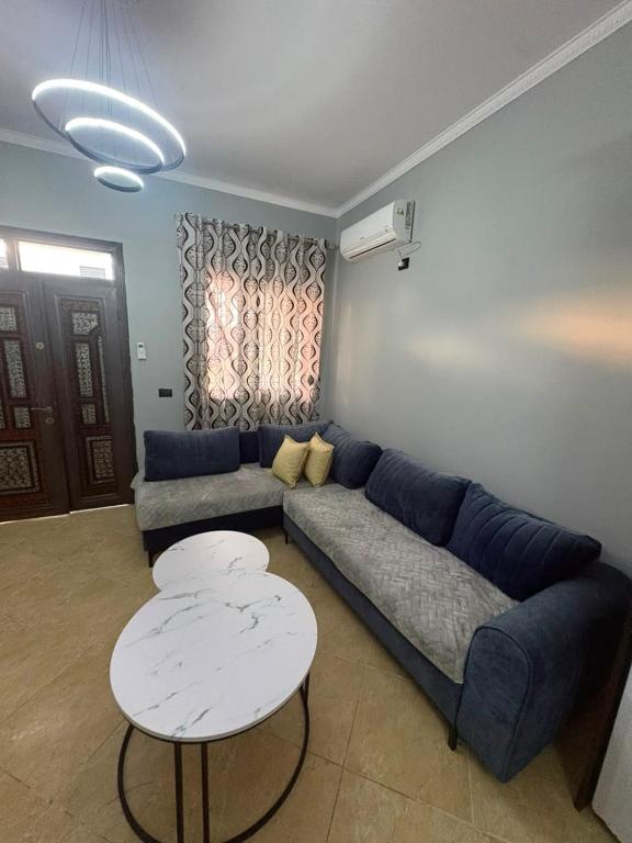a living room with a blue couch and a table at Casa bushi in Kamëz