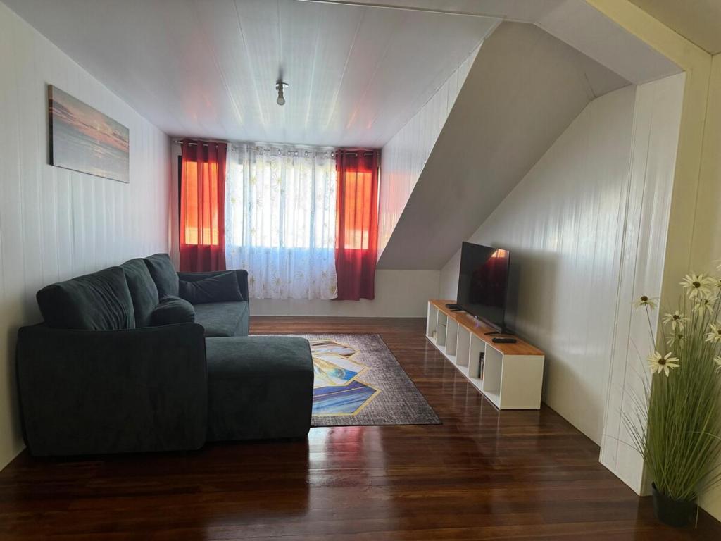 a living room with a couch and a television at La Maison Blanche, 2 bedrooms in Macouria