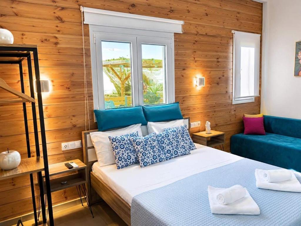 a bedroom with a bed and a blue couch at Divine Studios A1 in Elafonisos