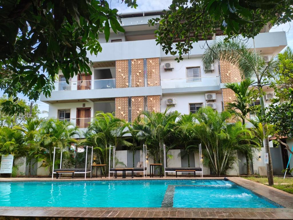 a hotel with a swimming pool in front of a building at Studio by Jackfruit in Arambol