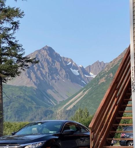 a black car parked next to a mountain at Pond Studio Apartments in Seward