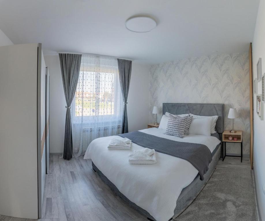 a bedroom with a large white bed with a window at Apartman Nika-Self check-in,Free Parking in Vukovar