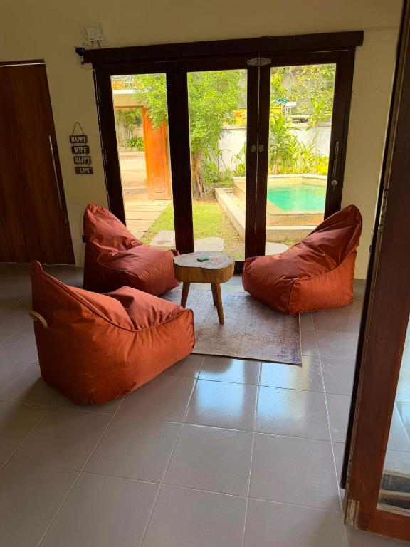 a living room with two orange pillows and a table at The Purple Pineapple Beach Hostel in Kuta Lombok