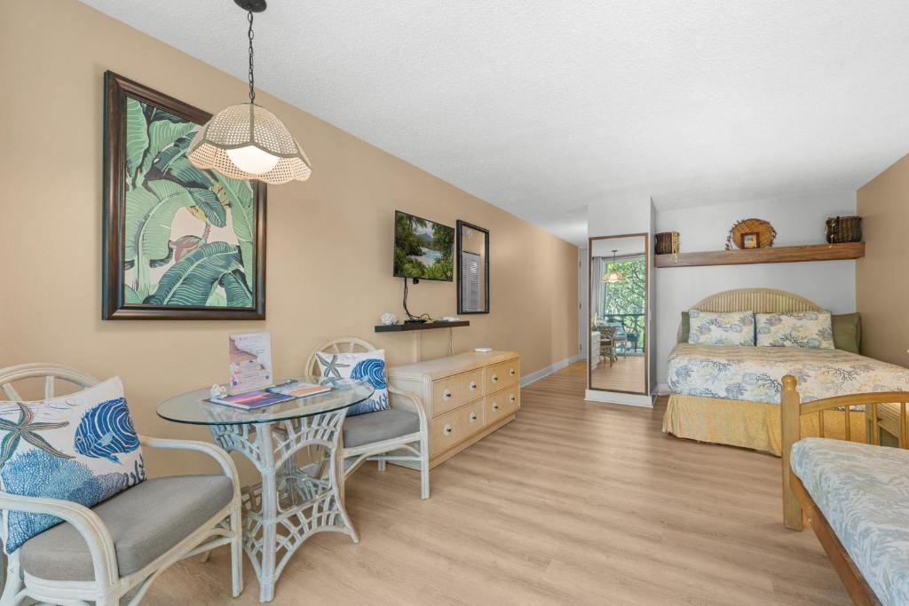 a bedroom with a bed and a table and chairs at Kona Islander Inn#228: Located in downtown Kona! in Kailua-Kona