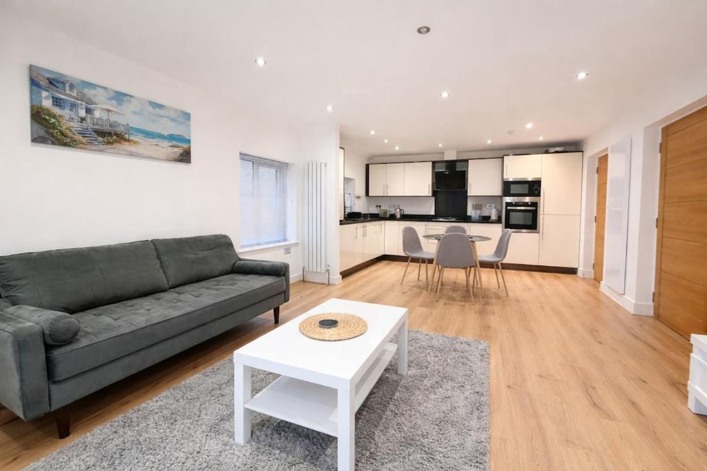 a living room with a couch and a table at Relax in a Spacious 2-Bed Pinner Hideaway in Northwood