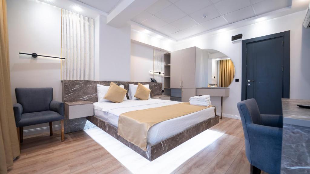 a bedroom with a bed and a blue chair at Kıyı Hotel Restaurant in Gebze