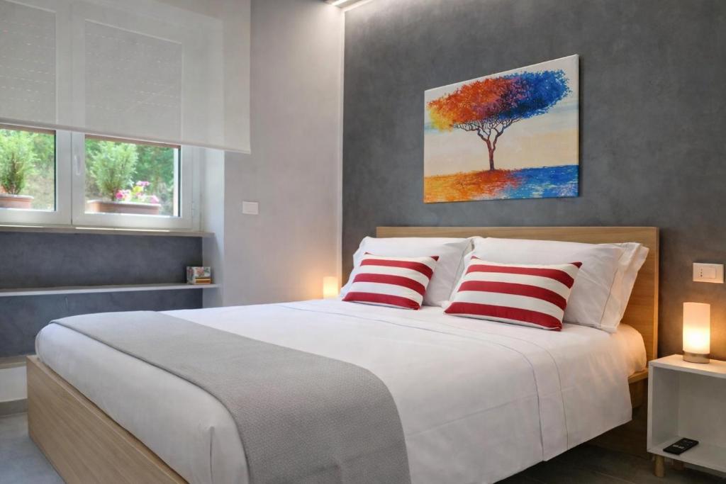 a bedroom with a large bed with two red pillows at Casa Armonia Apartment Sulmona con Cucina in Sulmona
