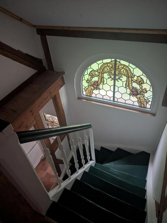 a staircase with a stained glass window above it at Zum altem Forsthof Grittel in Grittel