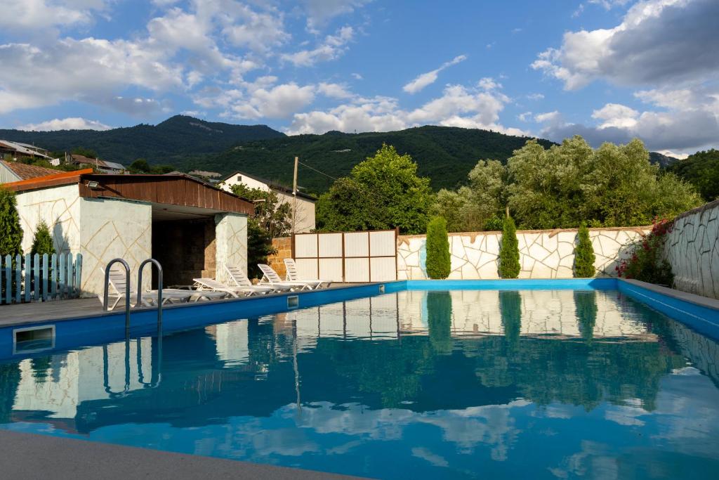 a swimming pool with blue water and mountains in the background at Spitak tun in Ijevan