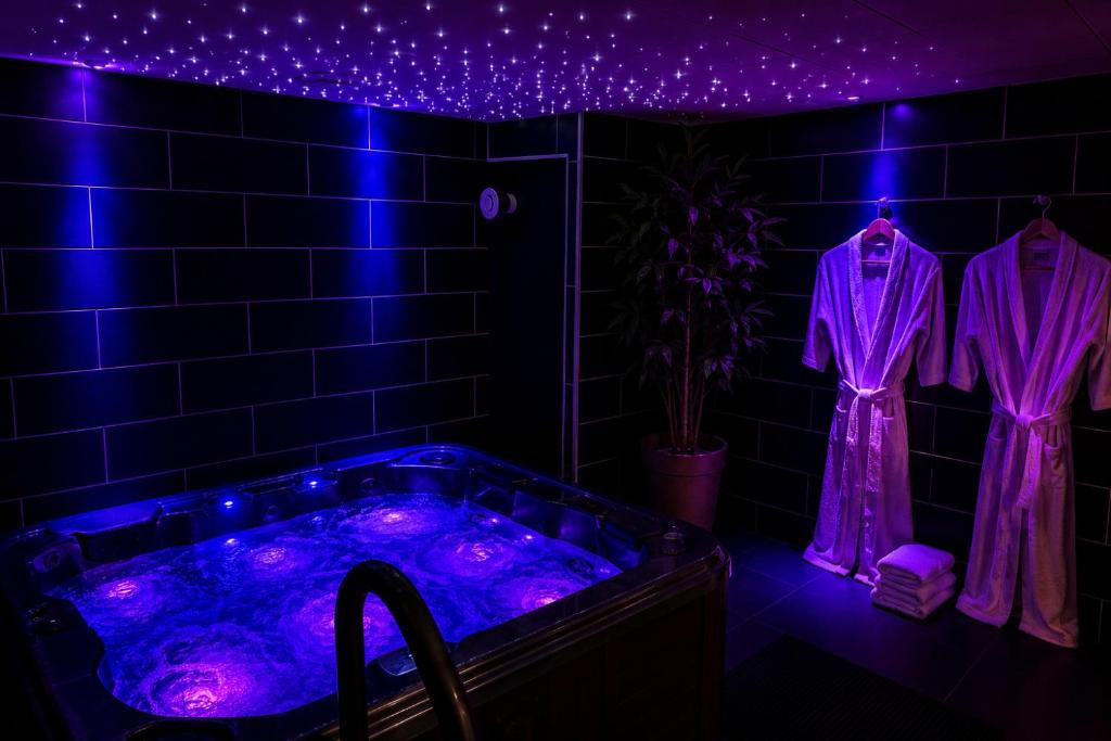 a bathroom with a hot tub with purple lights at BLOM Spa privatif près de Douai, salle de massage, petit-déjeuner inclus in Guesnain