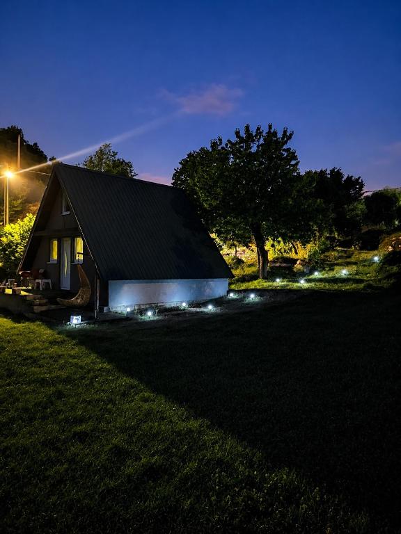 a house with lights in the yard at night at Villageescape in Cetinje