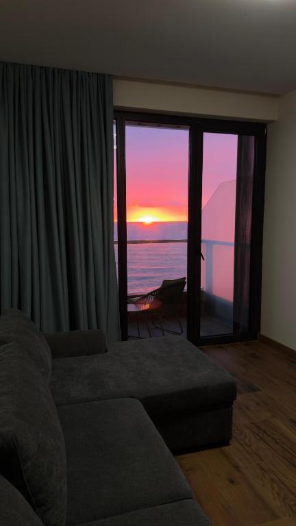 a living room with a couch and a view of the ocean at Go Bamboo Beach Apartments in Ts'ikhisdziri