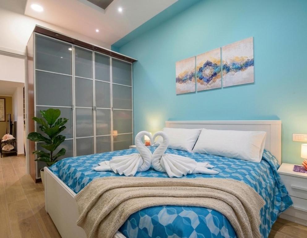 two swans sitting on a bed in a bedroom at Villa del Mare Virgo Home in Nettuno