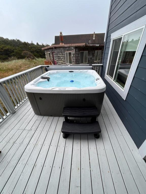 a hot tub sitting on the deck of a house at Sunset Shores in Pacific City