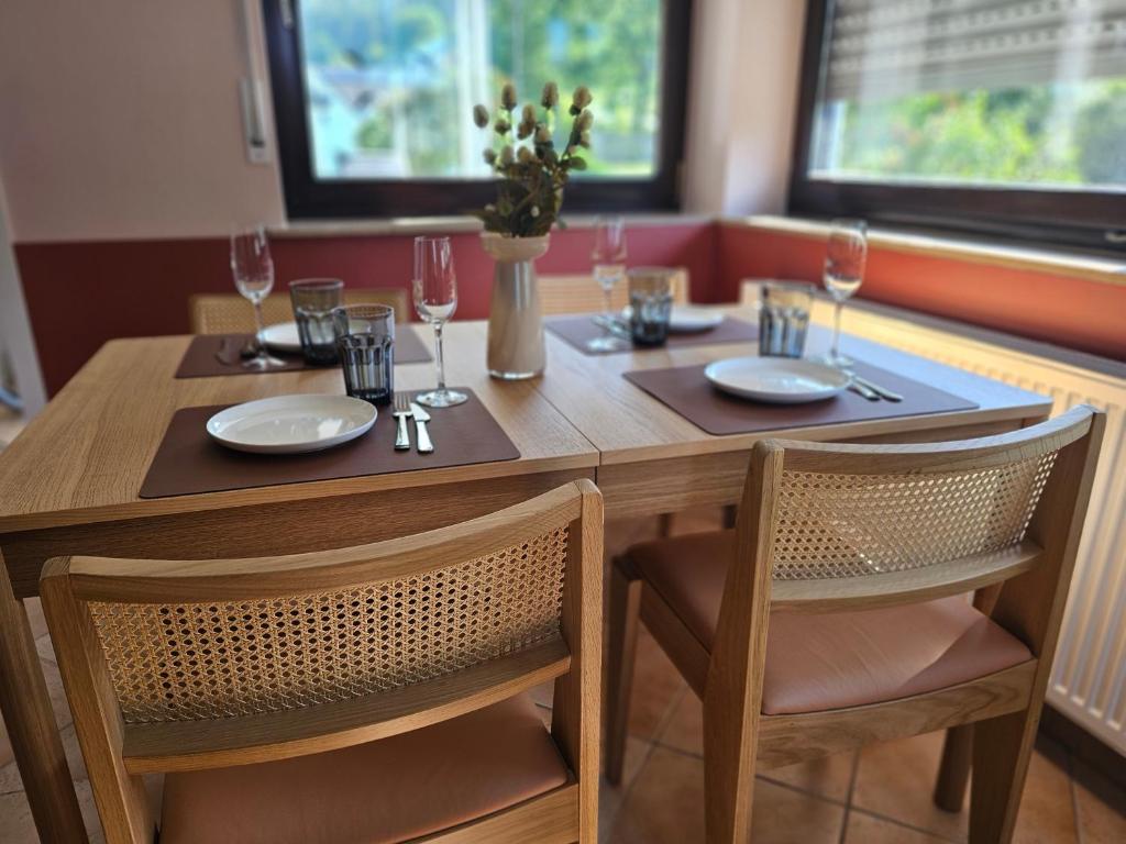 a wooden table with two chairs and a table with wine glasses at WOLL Forest in Schmallenberg