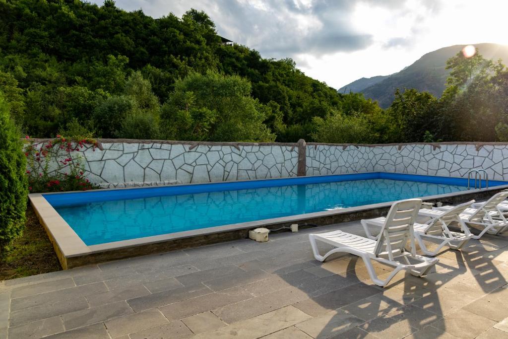 a swimming pool with chairs next to a fence at Spitak Tun in Ijevan