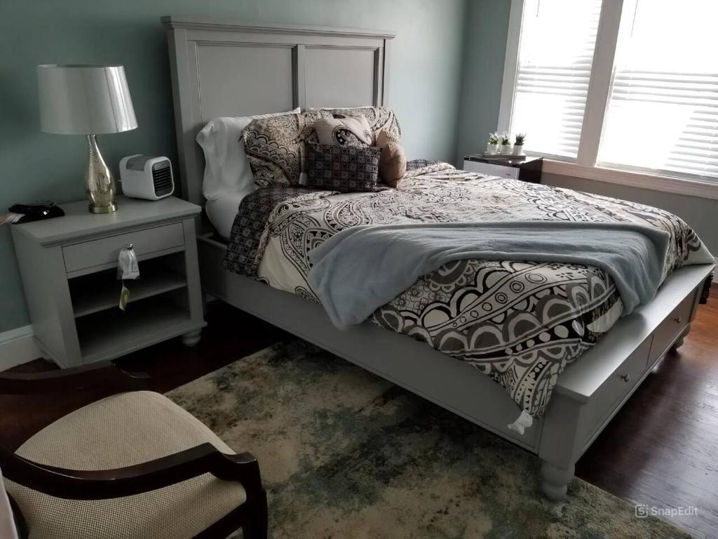 a bedroom with a bed and a chair and a lamp at Casa Castor • Private Room 2 in Chelsea