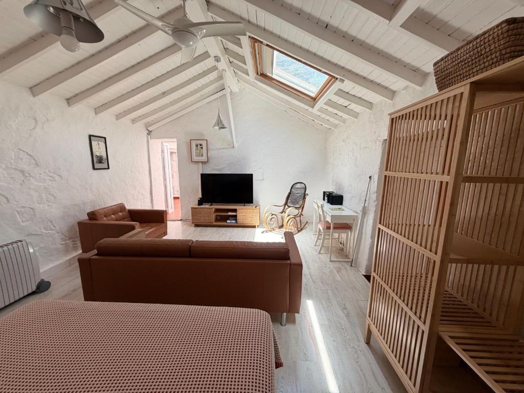 a living room with a couch and a television at Casa Cueva Tejeda 2 dorm in Tejeda