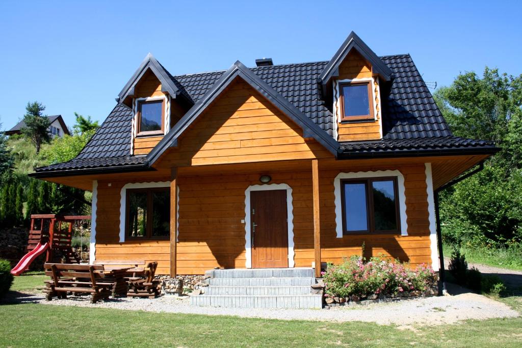 a small wooden house with a picnic table in front of it at LEŚNY DWOREK 2 in Wołkowyja