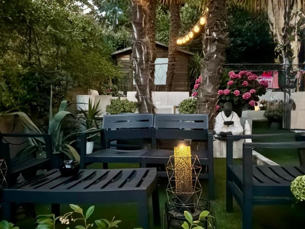 a person sitting on a bench in a garden at B&B Villa Rivabella in Bologna