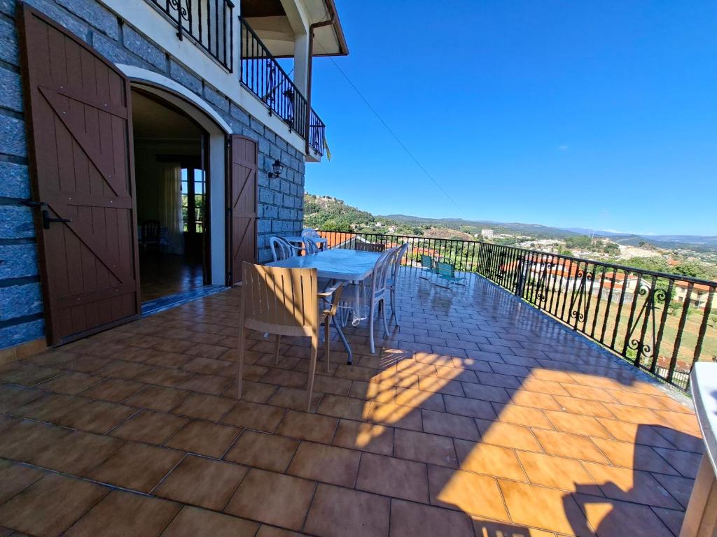 a patio with a table and chairs on a balcony at Sitio dos Machados in Póvoa de Lanhoso