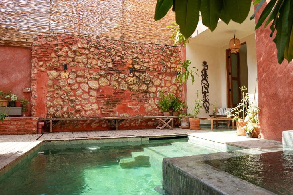 a swimming pool in front of a brick wall at Domus Santa Barbara Apartments with Pool in Santo Domingo