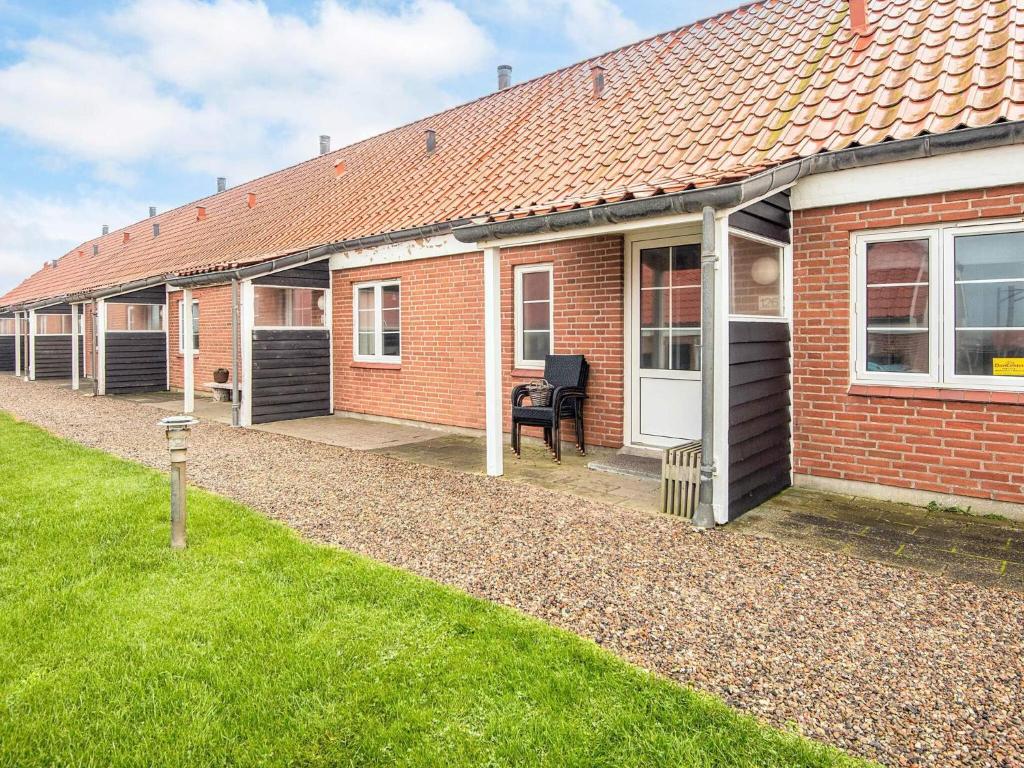a red brick house with a lawn in front of it at 4 star holiday home in Lemvig in Lemvig
