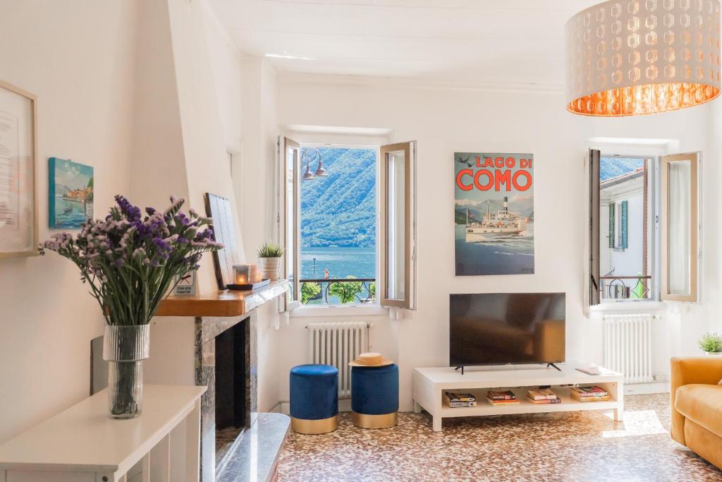 ein Wohnzimmer mit Kamin und Fernseher in der Unterkunft Family Nest on Lake Como by Rent All Como in Argegno