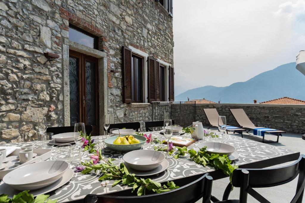 a table with plates and bowls of food on a patio at Castravalva Villa by Rent All Como in Mezzegra