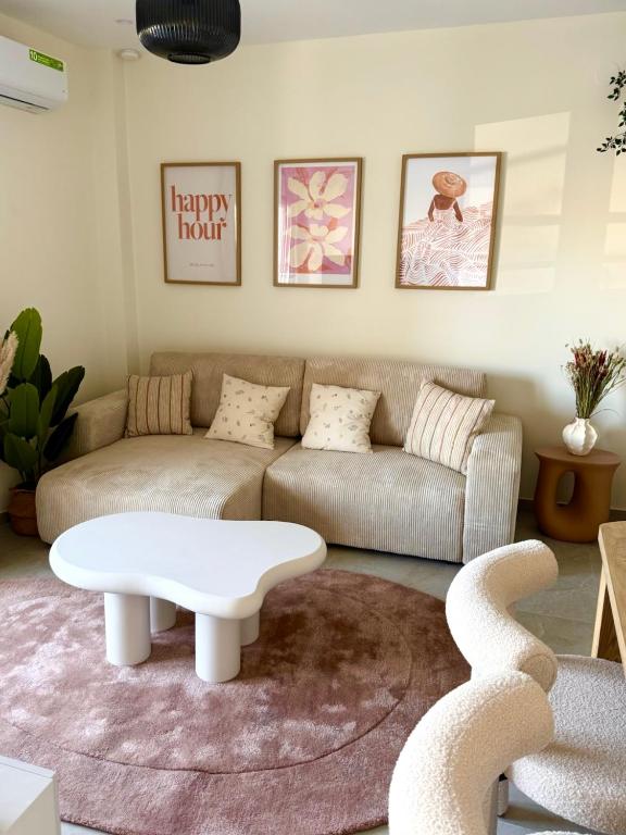a living room with a couch and a coffee table at Covea by the Sea Boho Seaside Apartment, 400 m from the Beach in Perea
