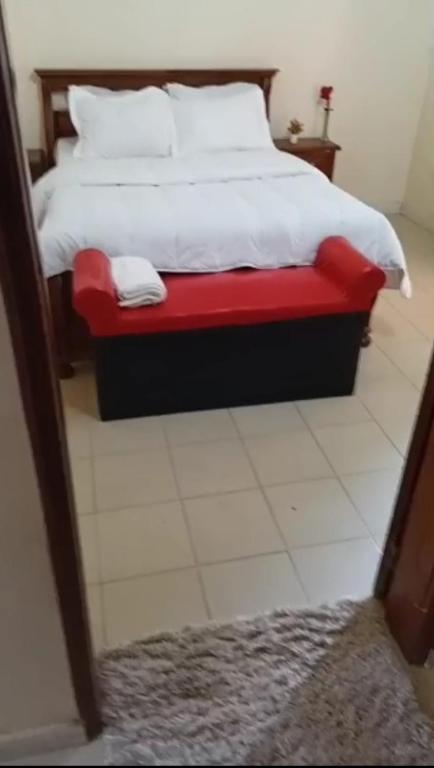 a bedroom with a bed with a red bench on it at EHBC Loc in Tambacounda