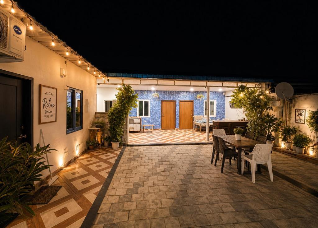 a patio with a table and chairs and lights at Aanadam Resort in Jaipur