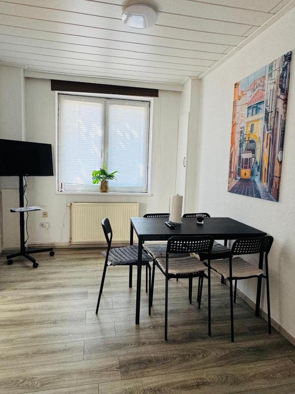 a room with a table and chairs and a television at CityStay House 42 in Bremerhaven