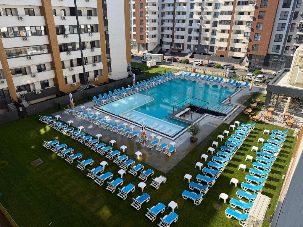 Draufsicht auf ein Schwimmbad mit Stühlen und Tischen in der Unterkunft DAW Residence 81 in Popeşti-Leordeni