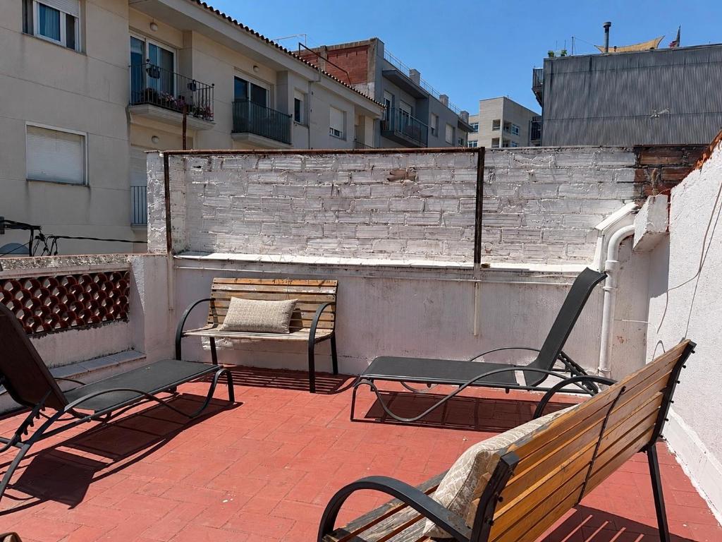 a balcony with two chairs and a bench on a building at CozyCatalonia - Exclusive Attic in Central Blanes in Blanes
