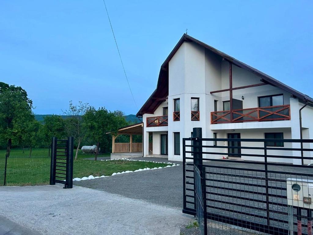 a white house with a gate in front of it at Vila Safir MM in Şurdeşti