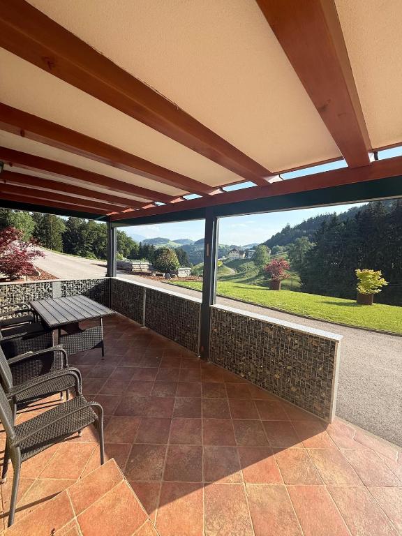 a patio with a table and benches and a view at Wohnung im Grünen in Sankt Andrä